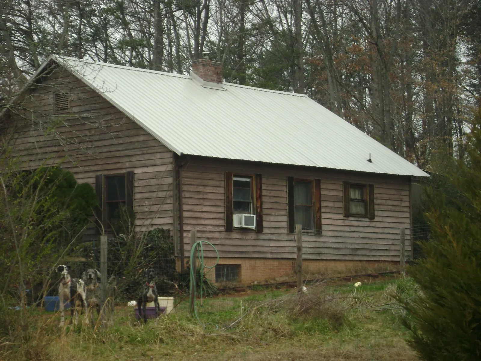 White metal roof on an old wood sided farmhouse, from a Asphalt Shingle Roof Repair job in Atlanta